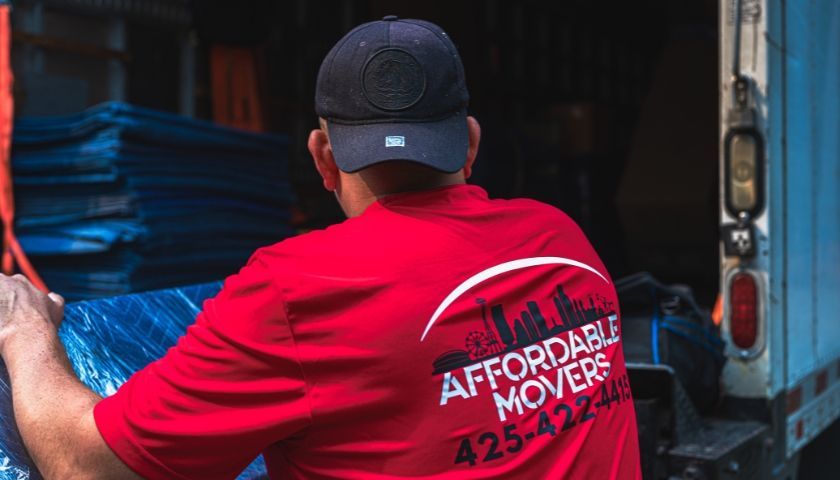 Person loading a moving truck wearing a red 